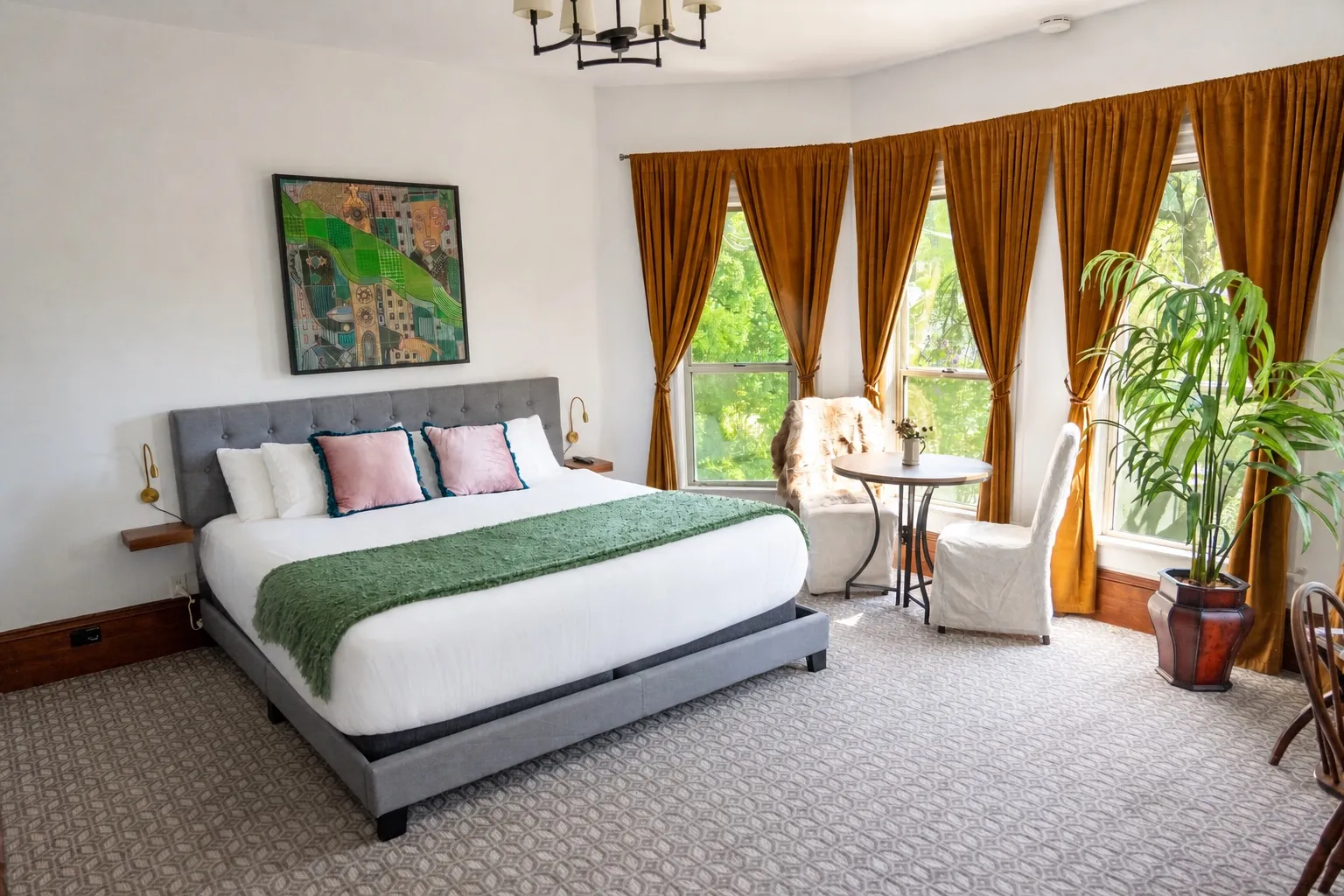 The Empire Room: a king bed beneath a five-window bay hung with gold velvet curtains